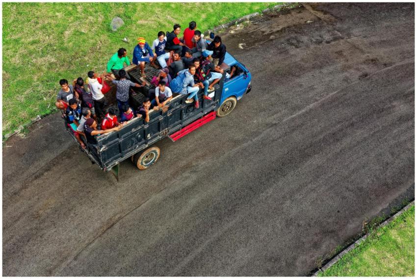 Aerial shot capturing a truck full of people trave