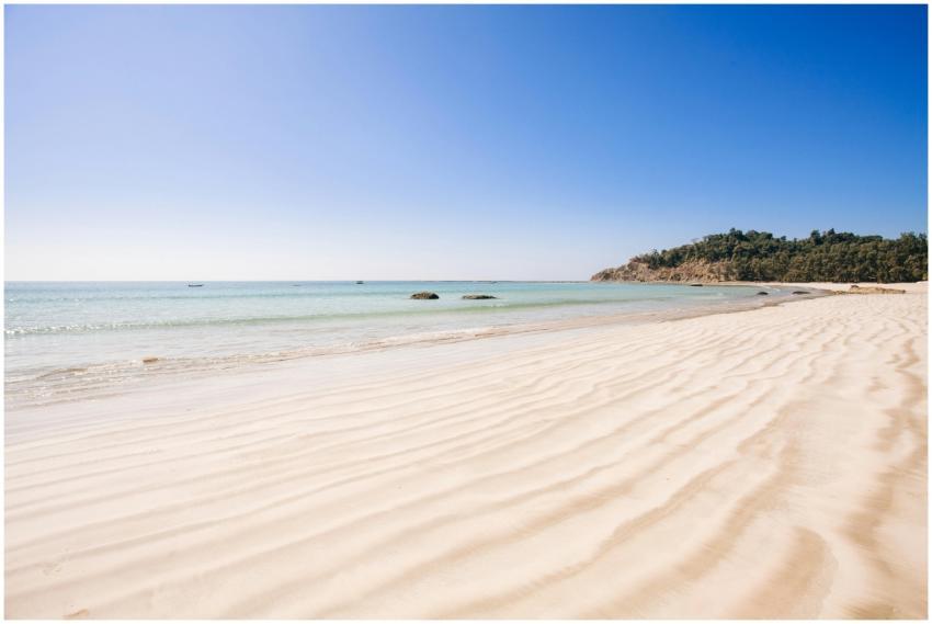 A serene view of a tranquil beach with clear ocean
