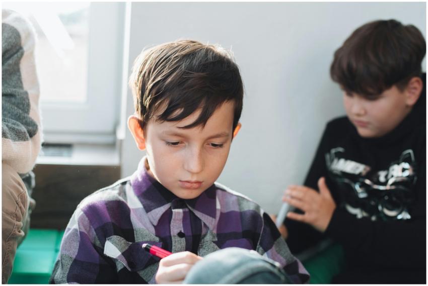 A young schoolboy concentrating while writing with