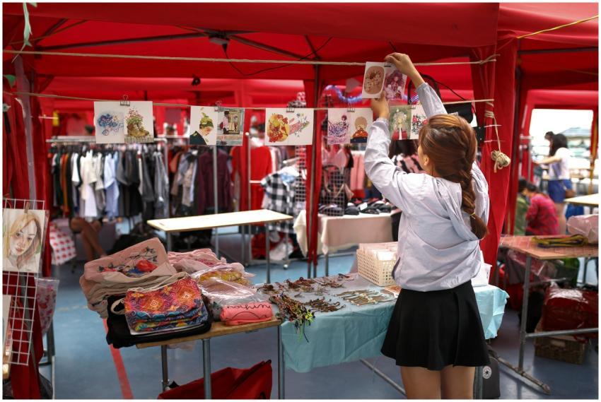 A woman organizes art prints in a vibrant outdoor