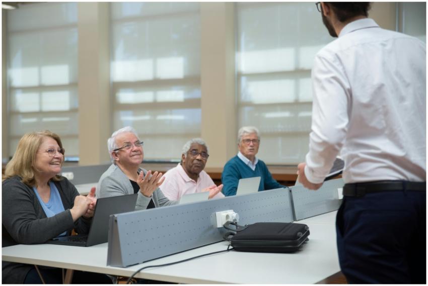 Senior adults attend a computer class, led by an i