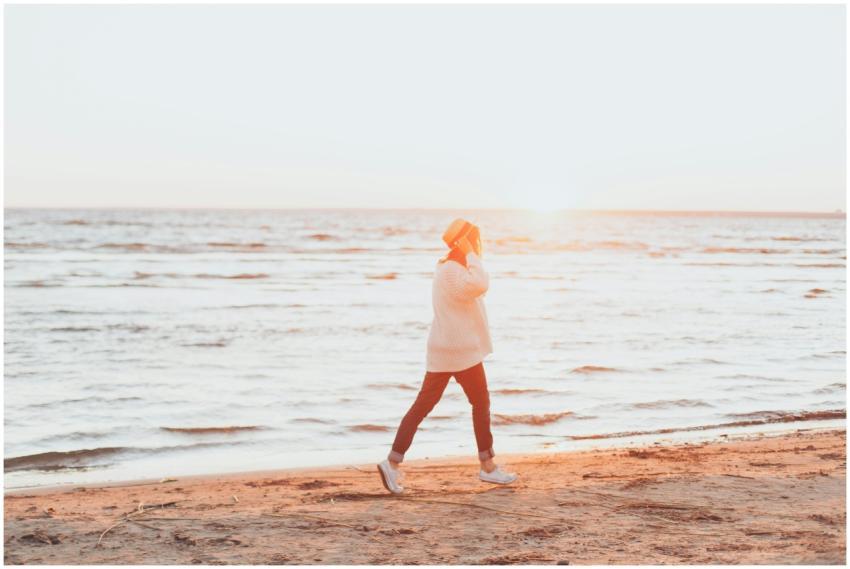A woman enjoys a peaceful walk along the beach dur