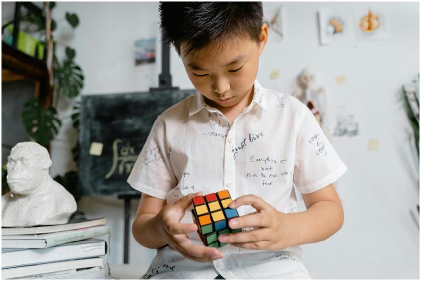 A young boy intensely solving a Rubik's Cube in a