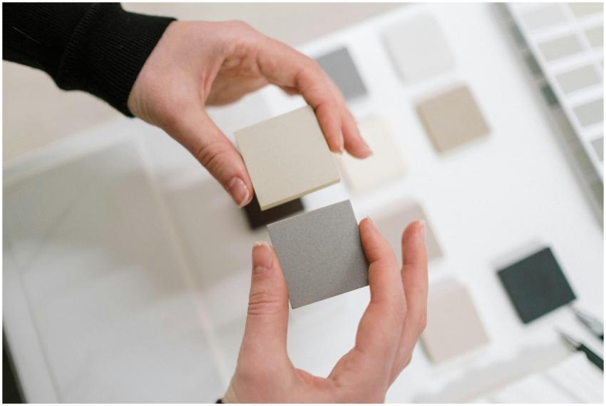Hands holding neutral color swatches for interior