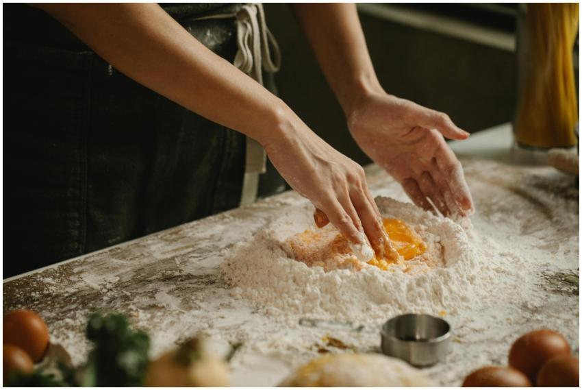 Hands kneading dough with eggs and flour for homem