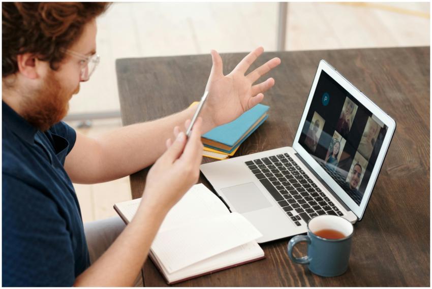 Man engaged in a virtual meeting at home with lapt