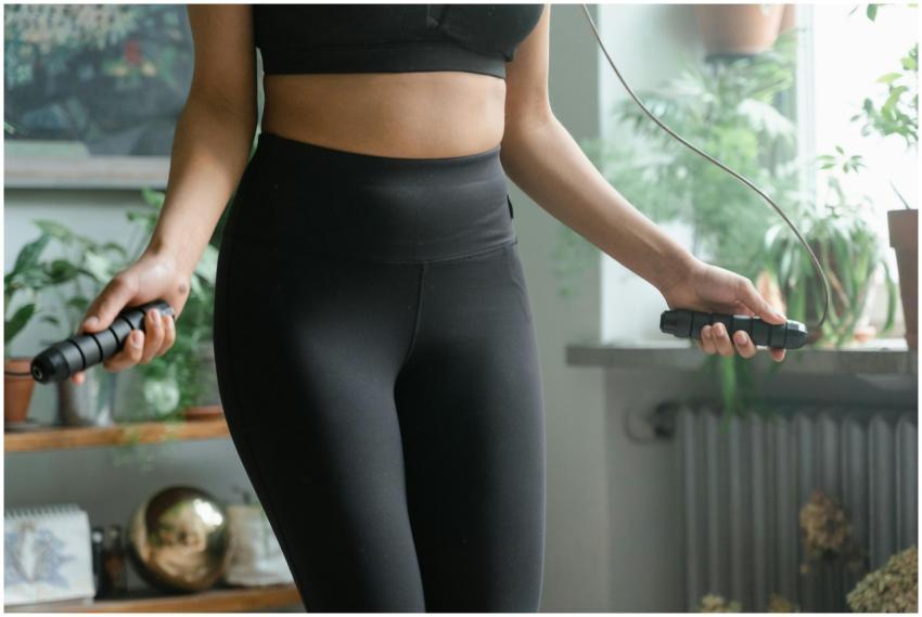 A woman working out inside with a jump rope, promo