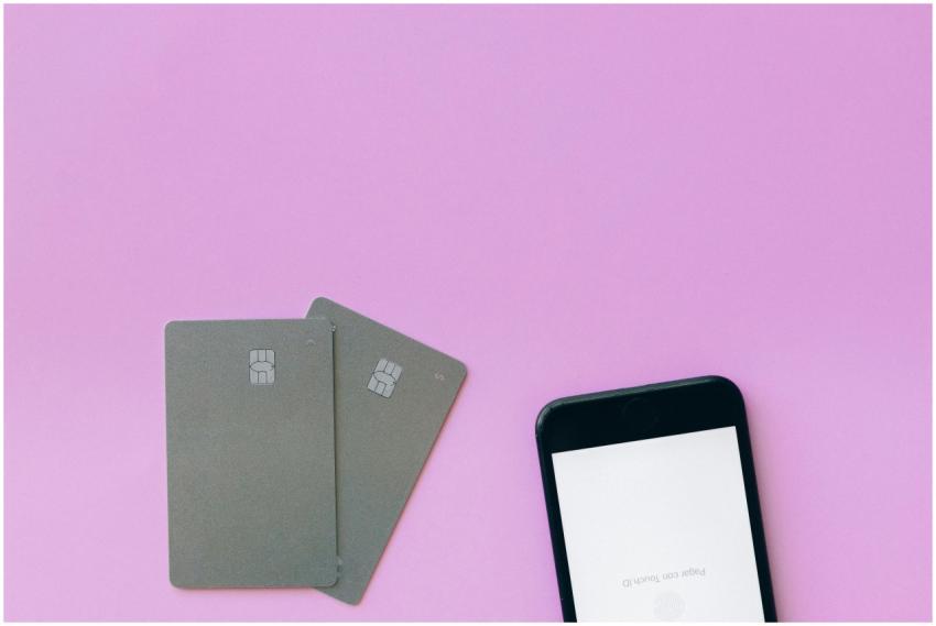 Flat lay of credit cards and smartphone on pink su