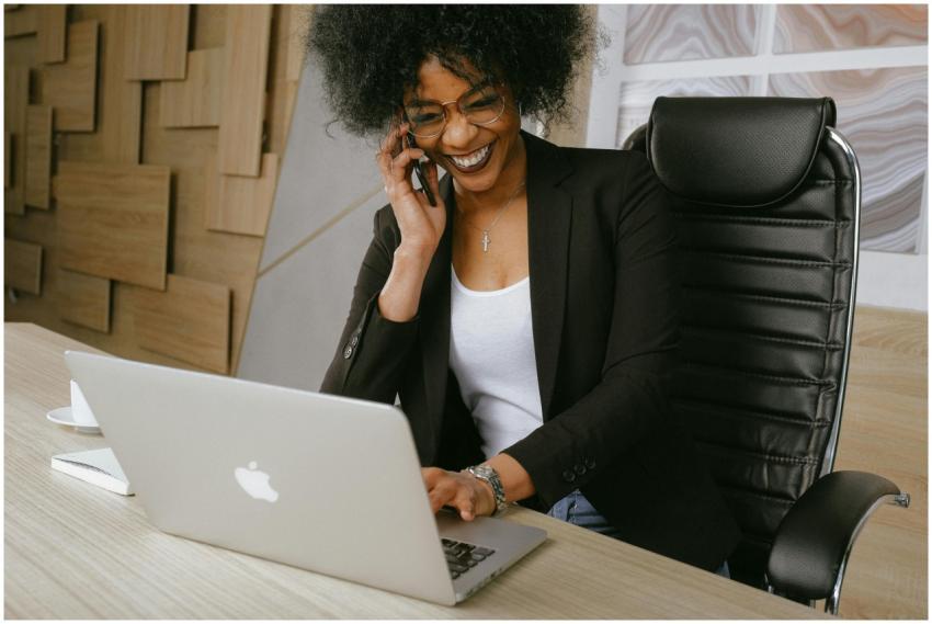 Smiling woman on phone call while working on a lap
