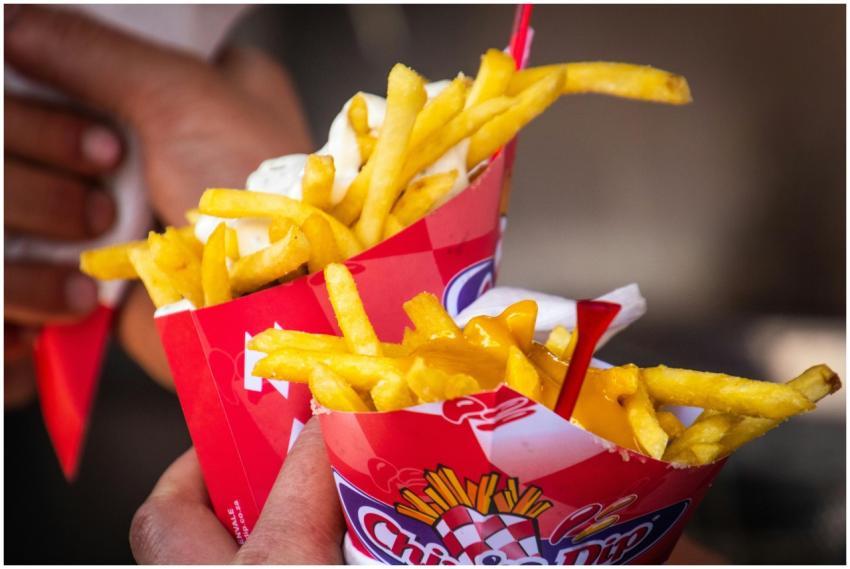 Tasty cheese-covered french fries held closely. Pe