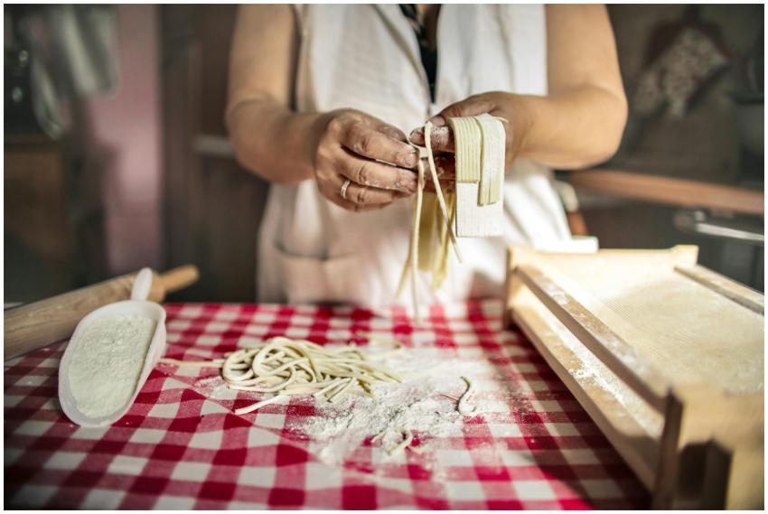 Unrecognizable cook in uniform standing at table d