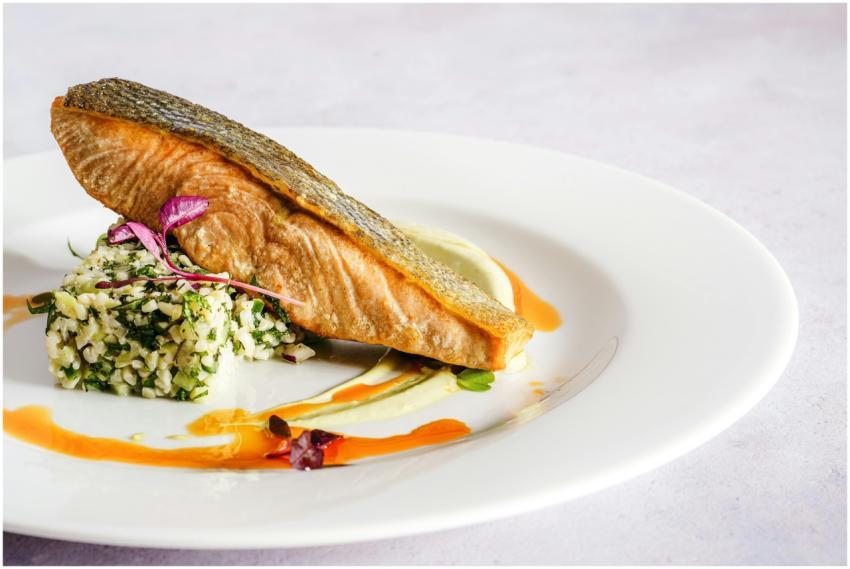 A beautifully plated salmon dish with quinoa, herb