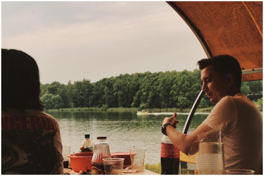 Two people enjoying a lakeside picnic with a calm