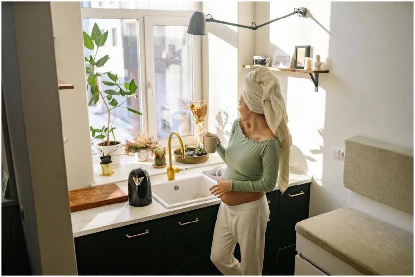Pregnant woman with head towel enjoying morning te