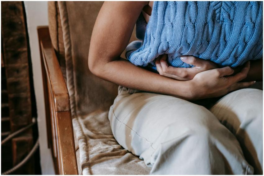 Crop unrecognizable female touching belly while ha