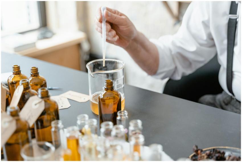 A person blends essential oils in glass bottles fo