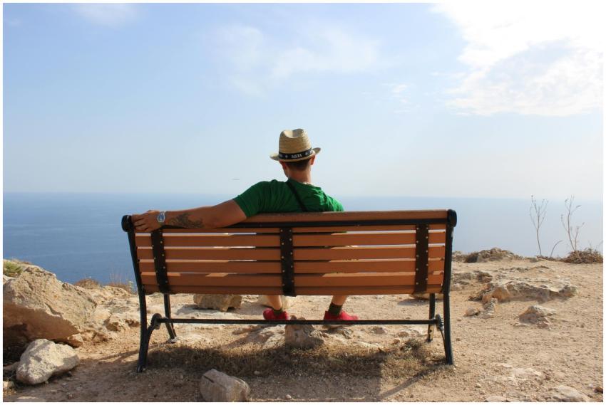 Man relaxing on a bench with a peaceful ocean view
