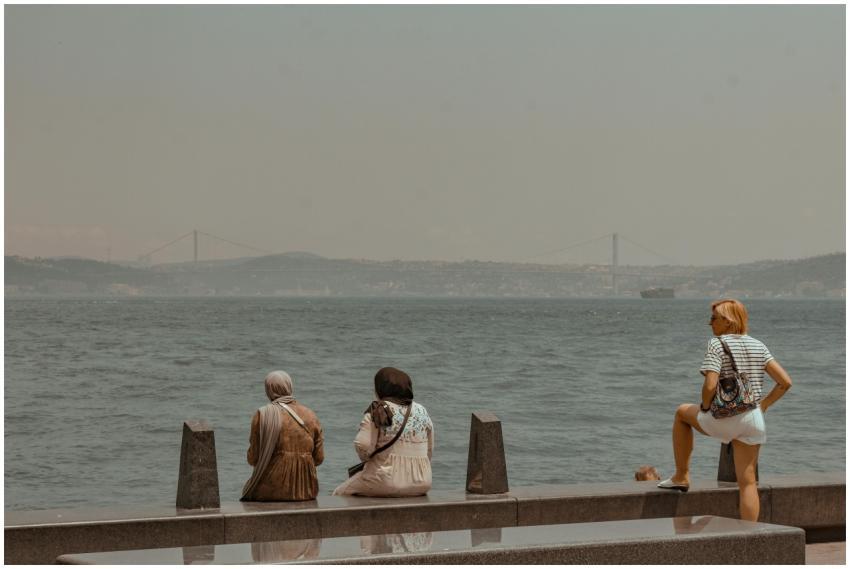Three women relaxing on a promenade with the Bosph