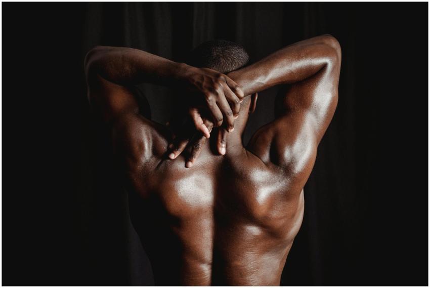 Strong men with defined muscles stretching his bac