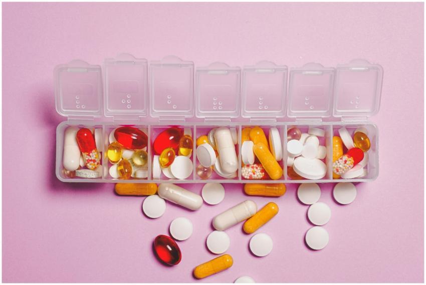 A variety of pills in a weekly pill organizer on a