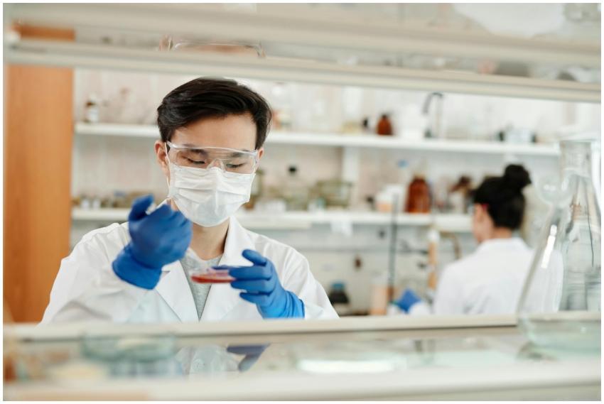 Researcher in a lab coat working on a scientific e