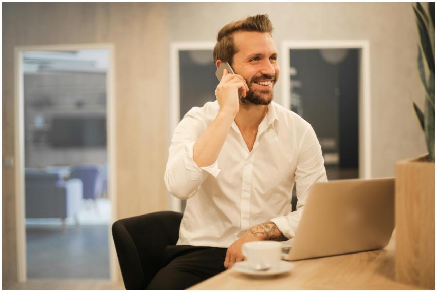 Happy businessman in white shirt on phone call at