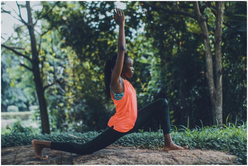 Woman practicing yoga outdoors in a serene forest