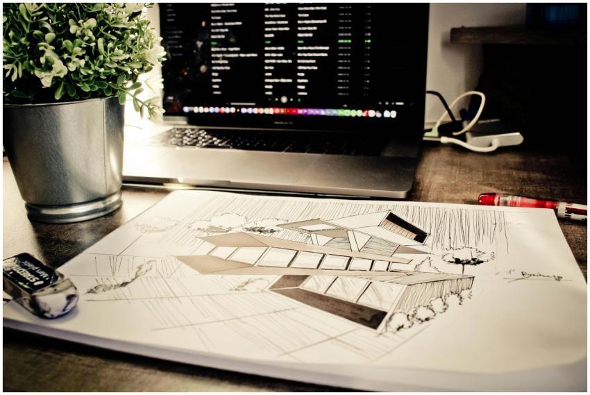 Architectural sketch on a desk alongside a laptop