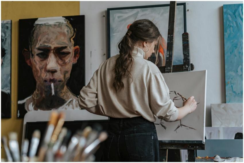 Female artist working on a canvas in a studio with