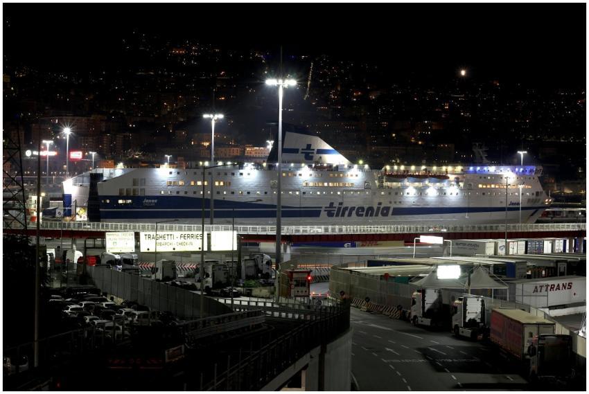 A brightly lit cruise ship moored at Genoa harbor