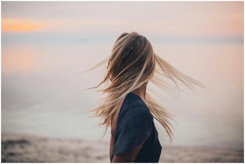 Blonde woman enjoying a serene sunset by the beach