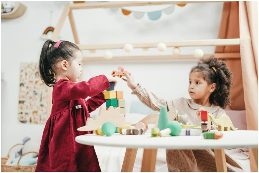 Two young girls enjoying playtime with wooden toys