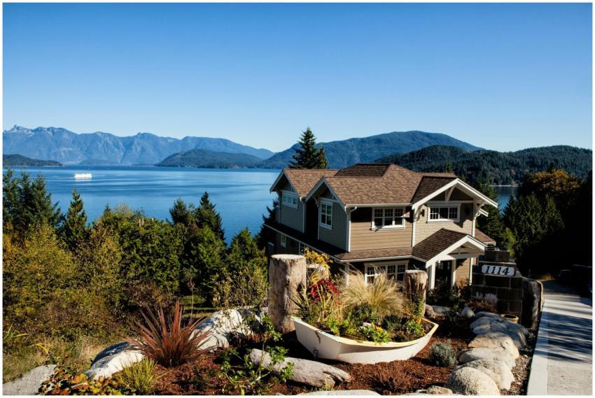 Scenic view of a charming house by the lake surrou