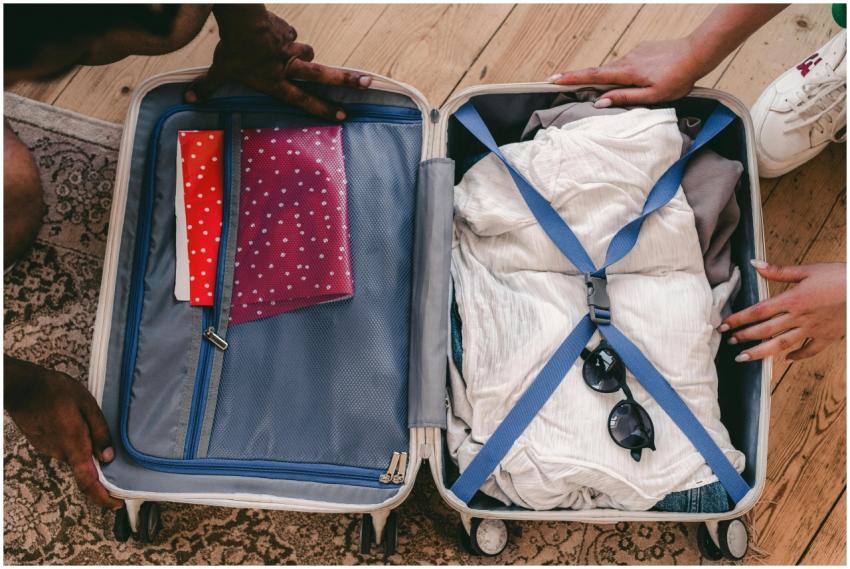 A neatly packed open suitcase with clothing and tr