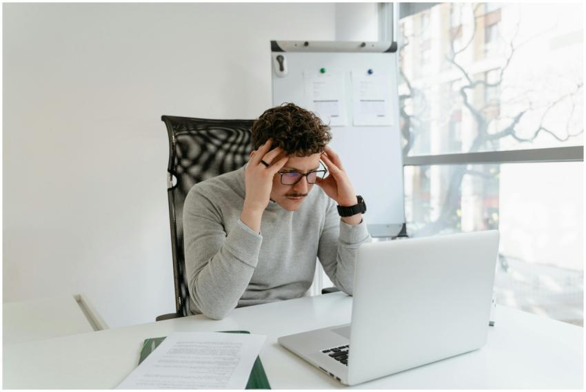 Young man concentrating on work at a desk with lap