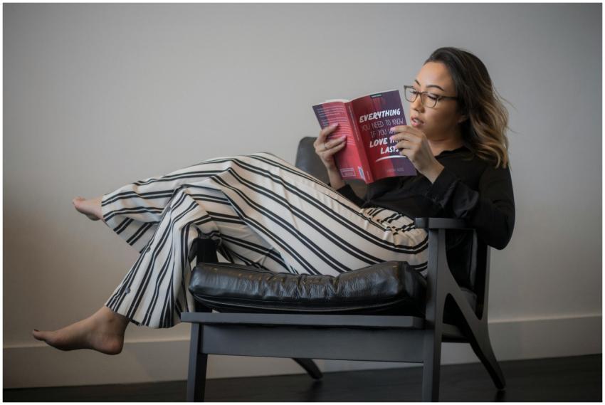 Young woman in striped pants reading a book comfor