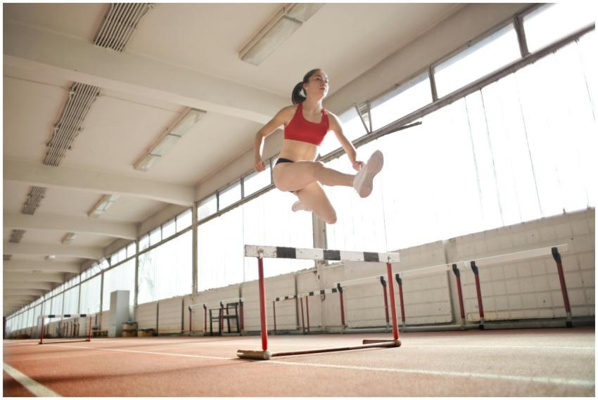 Dynamic action shot of a woman hurdling indoors, s