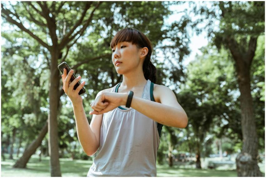 Young Asian woman checking her fitness tracker on