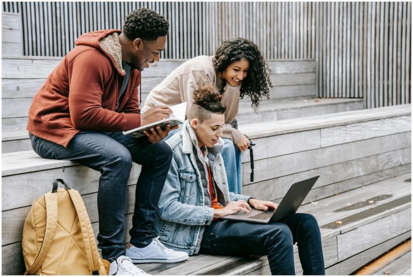 Young content multiracial friends browsing interne