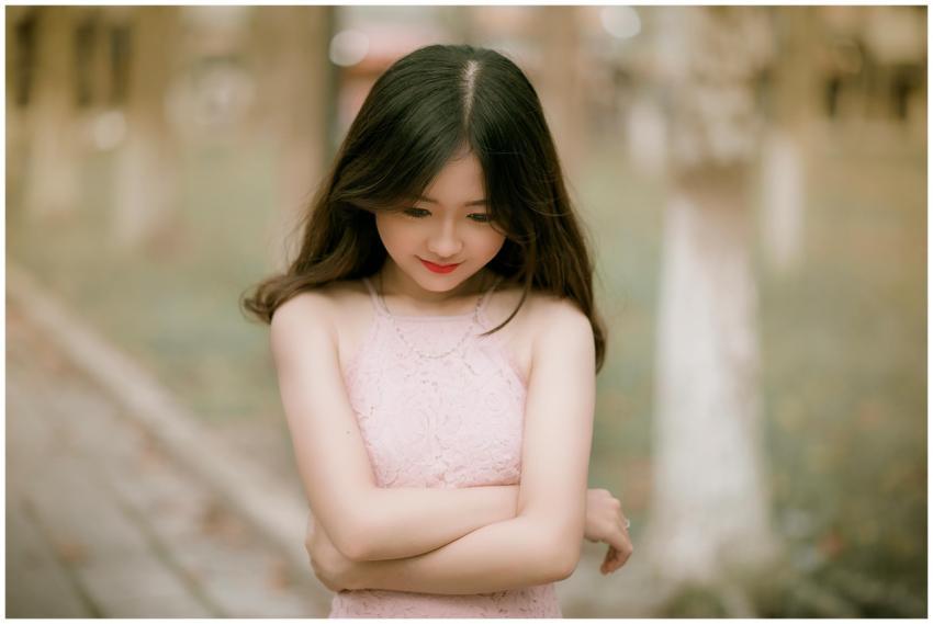 Portrait of a young woman with long hair in a pink
