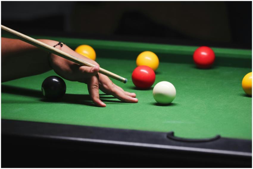 A close-up shot of a hand positioning a cue stick