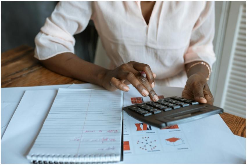 A professional woman calculating finances at a des
