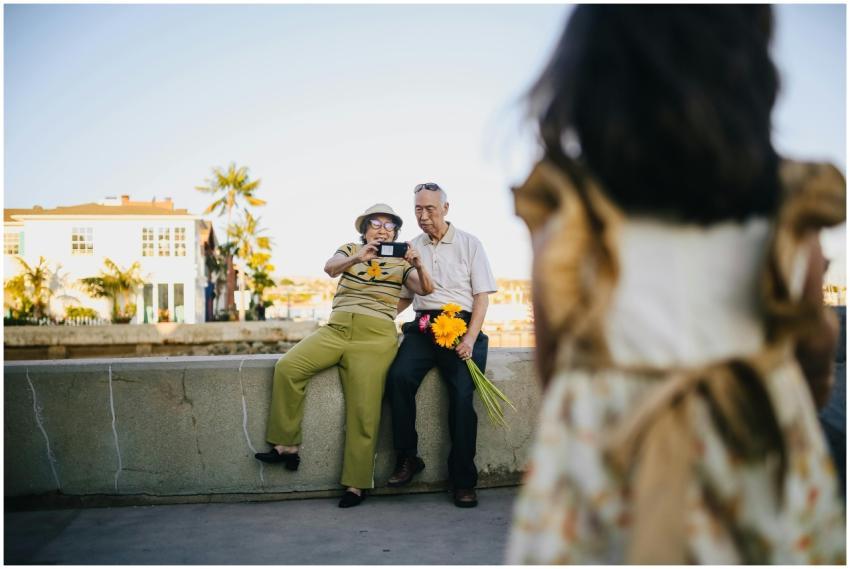 Happy elderly couple taking photos with grandchild