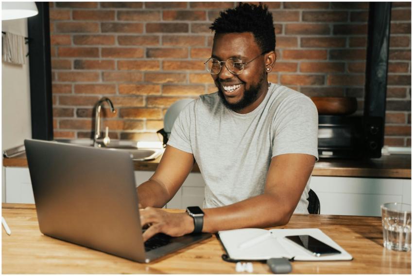 African American man smiling while working remotel