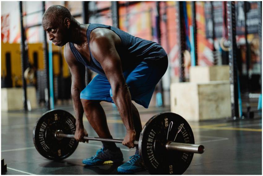 A muscular man lifting a barbell with intense focu