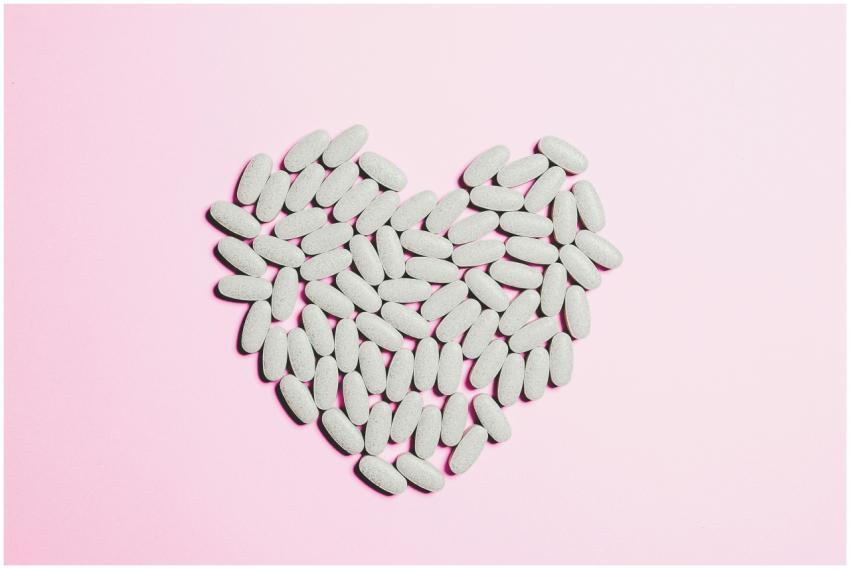 Artistic heart shape made from white pills on a pi