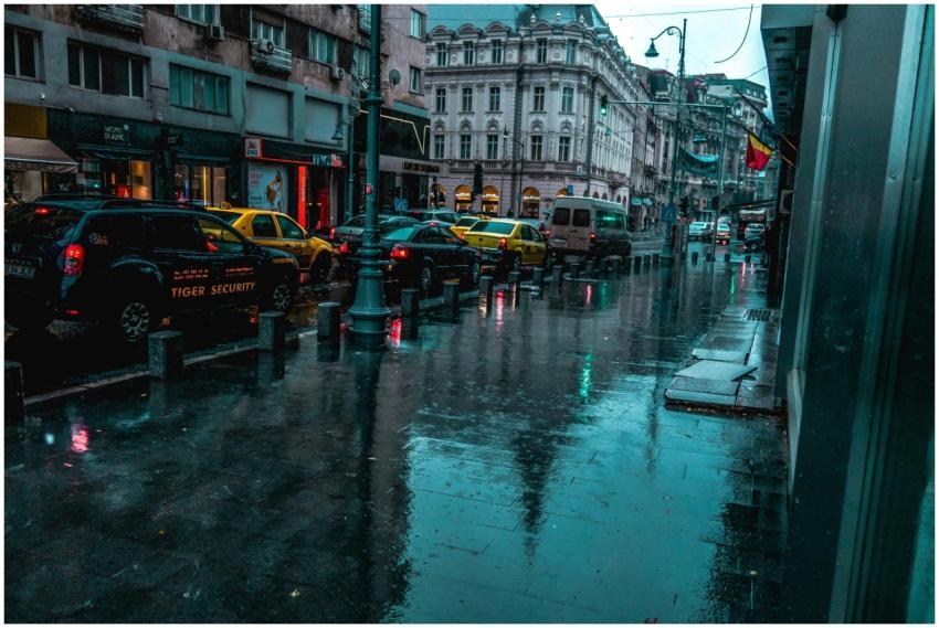 A wet city street with traffic and classic archite