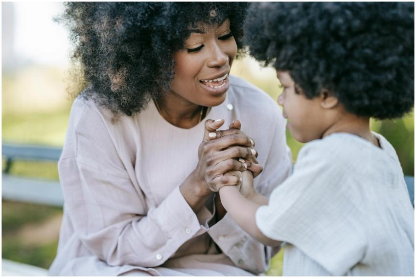 A mother and daughter with afro hair holding hands
