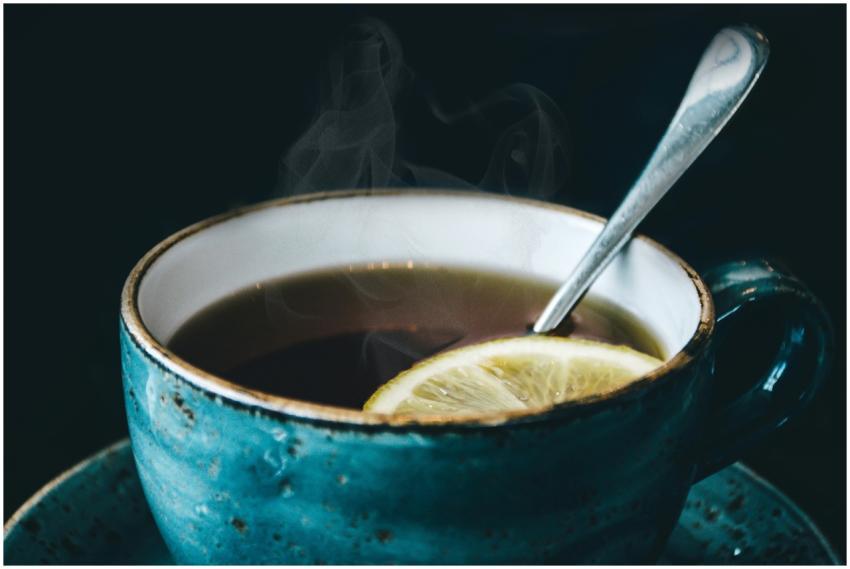 Close-up of aromatic steaming lemon herbal tea ser