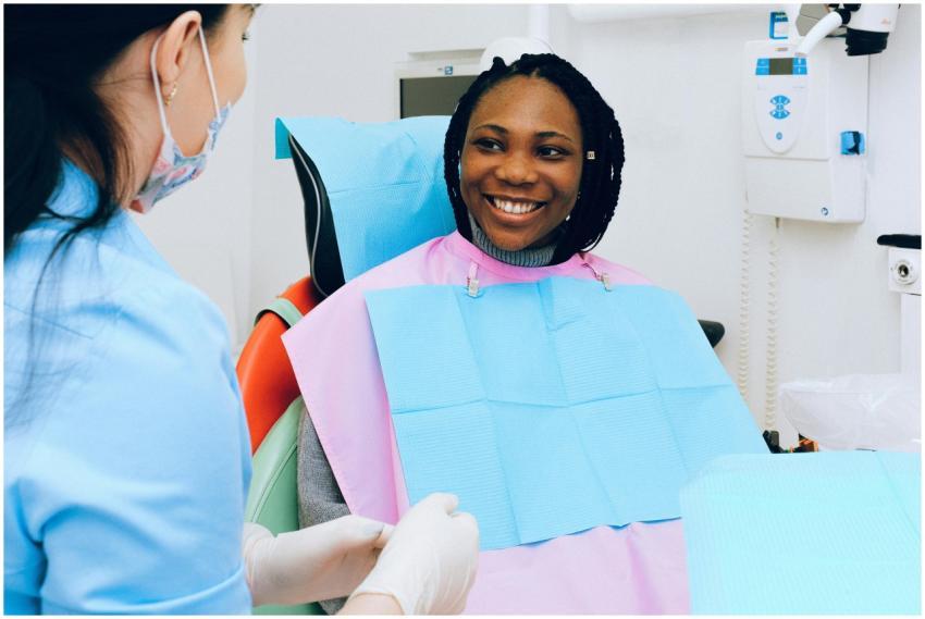 A smiling woman receives dental check-up from a pr